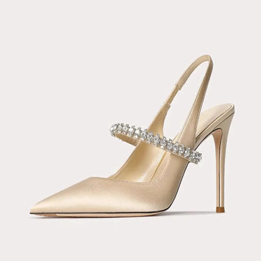 Beige high-heeled shoe with crystal embellishment on a light gray background